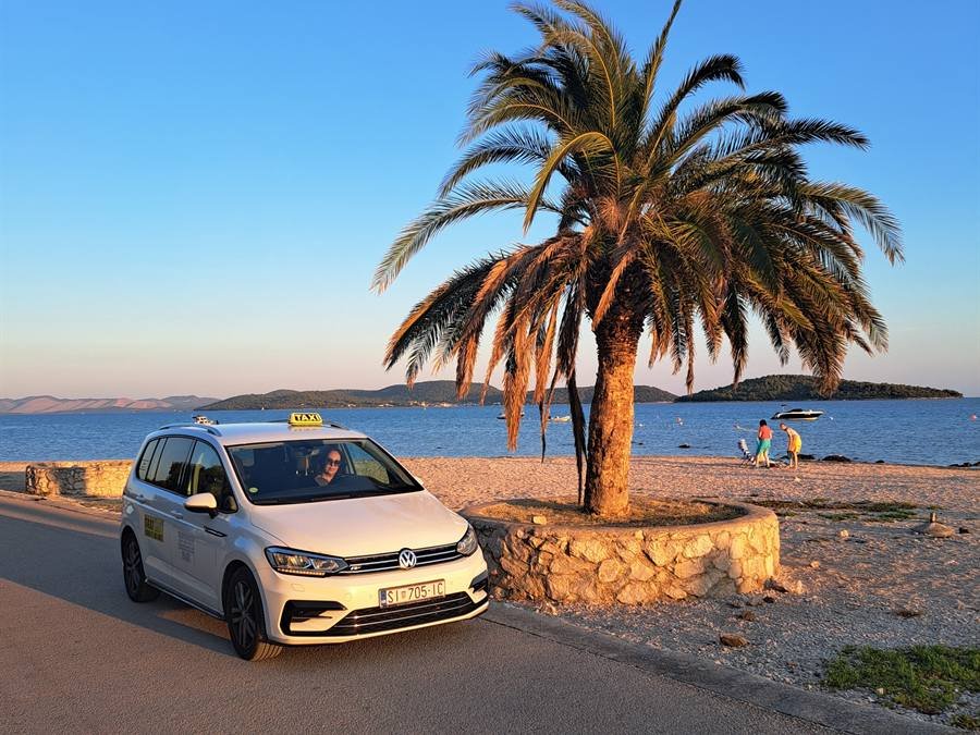 Taxi Ana Vodice car by a palm tree at sunset in Vodice